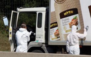 Investigators search  traces at  a  truck that  stands on the shoulder of the highway A4 near Parndorf south of Vienna, Austria, Thursday, Aug 27, 2015. At least 20 migrants were found dead in the truck parked on the Austrian highway leading from the Hungarian border, police said. (ANSA/AP Photo/Ronald Zak)