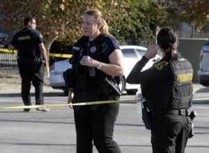 epa05052385 Law enforcement officers guard the road leading towards the scene of a shooting at the Inland Regional Center in San Bernardino, California, USA, 02 December 2015. A shooting at a government building west of Los Angeles left 'upwards of 14 people' dead and at least 14 wounded, San Bernardino Police Chief Jerrod Burguan says. EPA/MIKE NELSON