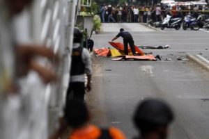 epa05101087 An Indonesian forensic police officer places body bags over victims' bodies at the scene of a bomb blast in Jakarta, Indonesia, 14 January 2016. Seven people, including four suspected attackers, died in bomb blasts and gunfire in the centre of the Indonesian capital Jakarta on 14 January, police said, in what the country's president described as an act of terrorism. EPA/RONI BINTANG AUSTRALIA AND NEW ZEALAND OUT