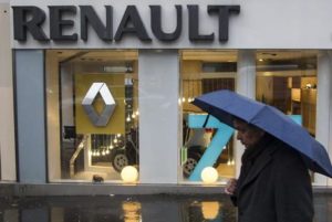 epa05101411 (FILES) A file photo dated 14 December 2012 showing a pedestrian with an umbrella in front of a Renault dealership in Paris, France. According to media reports on 14 January 2016, shares of French carmaker Renault have plunged after investigators apparently searched offices in connection with an emissions probe.  EPA/IAN LANGSDON