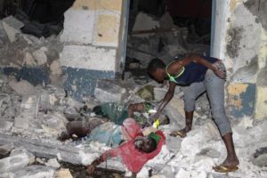 epa05182534 A man inspects bodies in the rubble at the scene of an attack in front of the SYL hotel in Mogadishu, Somalia, 26 February 2016. Gunmen from Somalia's Islamist militant group al-Shabab allegedly detonated a car bomb at the entrance of the hotel and stormed the building, according to reports. A witness said at least 10 bodies were seen on the ground. The latest attack by al-Shabab comes a day after another attack in the city claimed by al-Shabab. EPA/SAID YUSUF WARSAME PICTURE CONTAINS GRAPHIC CONTENT
