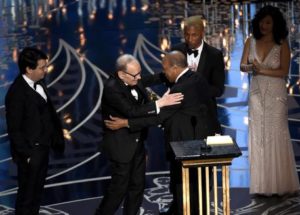 Quincy Jones, center, and Pharell Williams, right, present Ennio Morricone with the award for best original score for The Hateful Eight at the Oscars on Sunday, Feb. 28, 2016, at the Dolby Theatre in Los Angeles. (Photo by Chris Pizzello/Invision/ANSA/AP)