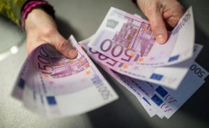 A bank employee holds 5,000 euros in 500-euro notes at a Sparkasse bank in Munich, Germany, 3 February 2016. ANSA/MATTHIAS BALK