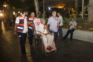 epa05352124 Israeli emergency personnel carrying Israeli woman at the scene of a shooting outside Max Brenner restaurant in Sarona market in Tel Aviv, Israel, 08 June 2016. According to reports, at least three people were killed and five seriously injured in a shooting in Tel Aviv's Sarona complex. EPA/JOHANNA GERON