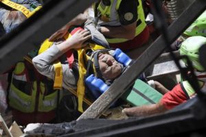 A man is rescued from the rubble of a building after an earthquake, in Accumoli, central Italy, Wednesday, Aug. 24, 2016. A devastating earthquake rocked central Italy early Wednesday, collapsing homes on top of residents as they slept. At least 23 people were reported dead in three hard-hit towns where rescue crews raced to dig survivors out of the rubble, but the toll was expected to rise as crews reached homes in more remote hamlets. (ANSA/AP Photo/Andrew Medichini) [CopyrightNotice: Copyright 2016 The Associated Press. All rights reserved. This material may not be published, broadcast, rewritten or redistribu]