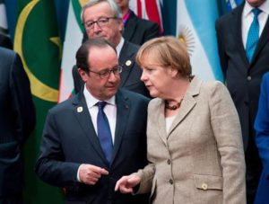 epa04490364 German Chancellor Angela Merkel (R) talks to French President Francois Hollande (L) watch by European Commission President Jean-Claude Juncker (C) as world leaders gather for a family photograph during the G20 summit at the Brisbane Convention and Exhibitions Centre (BCEC) in Brisbane, Australia 15 November 2014. The G20 summit will be held in Brisbane on 15 and 16 November. The G20 represents 90 percent of global gross domestic product, two-thirds of the world's people and four-fifths of international trade. EPA/KAY NIETFELD